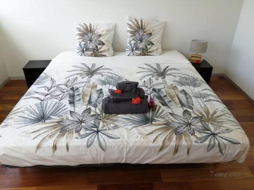 法兰西堡Bienvenue au 7ème ciel dans le spacieux T3 !的一张带白色床罩的床,上面有棕榈树
