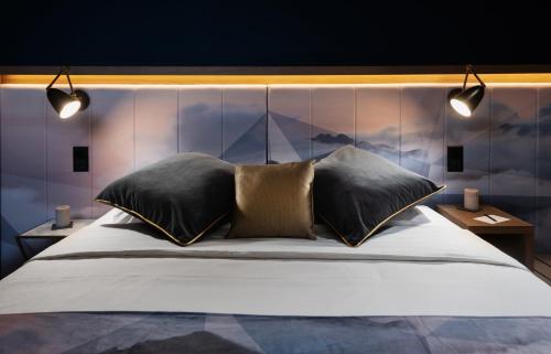 格林德尔瓦尔德冰川精品酒店 的一间卧室配有一张大床和两个枕头