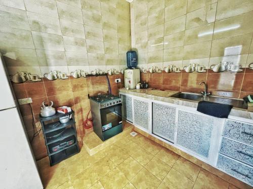 MisfāhAtiaf Jabal Shams house的小厨房配有炉灶和水槽