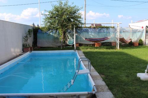 科斯蒂内什蒂Hacienda del Mar Costinesti的一个带吊床的庭院内的游泳池