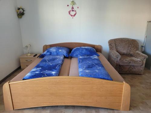 德累斯顿Mickten Hertz的一间卧室配有一张带蓝色枕头的床和一把椅子