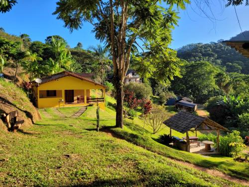 多明戈斯马丁斯Espaço inteiro: Casa de campo nas montanhas的绿色田野中间的黄色房子