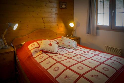 莱德萨阿尔卑斯T2 Meublé Tourisme 3 etoiles, pied des pistes-parking privé avec balcon et superbe vue的卧室内的一张带两个枕头的床