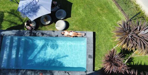 普利登堡湾日光浴普雷特酒店的躺在游泳池旁的草地上的人的头顶景色