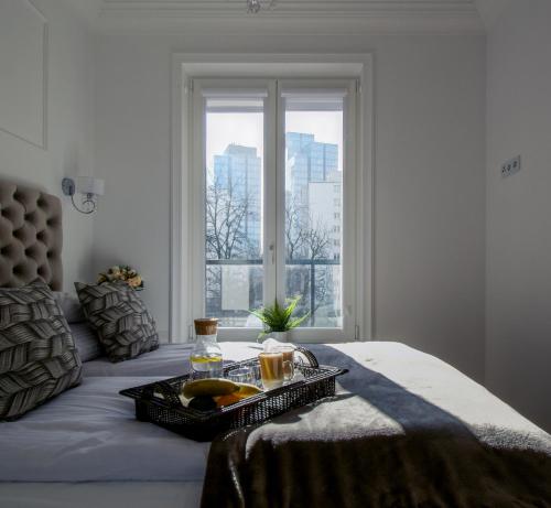 华沙Warsaw Seasons by Alluxe Boutique Apartments的床上的盘子,带窗户