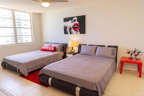 好莱坞Flip Flop Paradise in Hollywood Florida的一间卧室设有两张床和一张红色的桌子