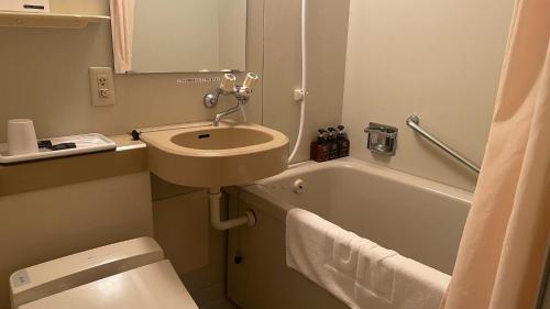 大分大分帝王酒店的浴室配有盥洗盆、卫生间和浴缸。