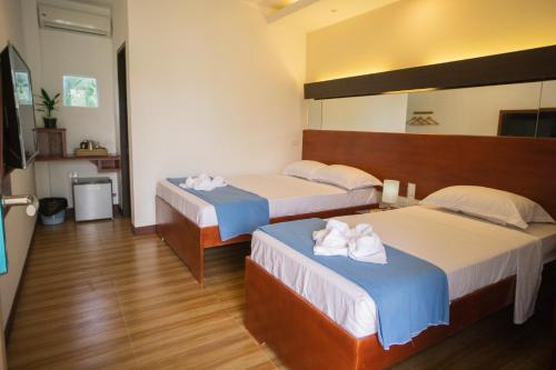 邦劳Siman Panglao的酒店客房,配有两张带毛巾的床