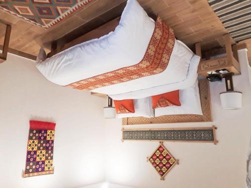 罕萨SERENA ALTIT FORT RESIDENCE的一间房间,配有三个枕头和一张床