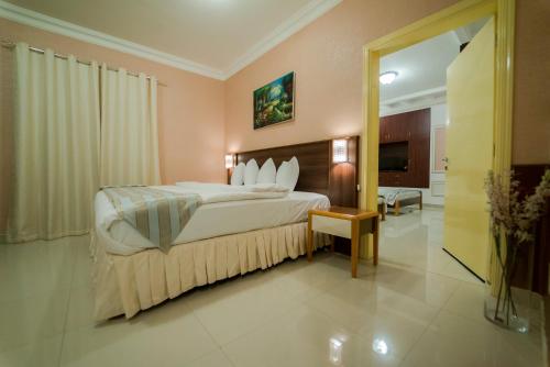 马斯喀特Al Ghubrah Plaza Hotel的酒店客房,配有床和电视