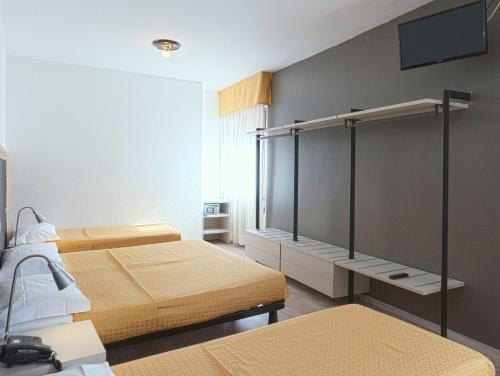 托尔博莱多利亚酒店的一间卧室设有两张床,墙上配有电视。