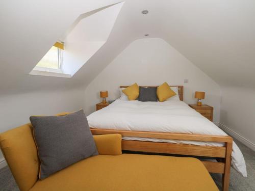 ShalfordBroadford Barn - Barn conversion in picturesque village的一间卧室配有一张床和一张黄色的沙发
