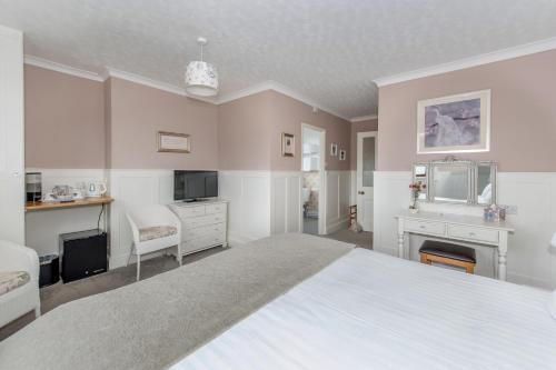 Wheddon CrossExmoor House的卧室配有一张白色大床和电视。