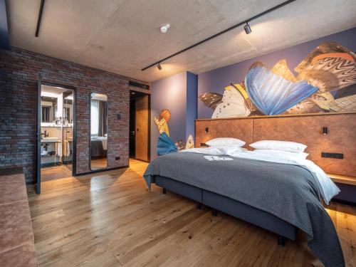 拜罗伊特Liebesbier Urban Art & Smart Hotel的卧室配有一张大床,墙上挂有绘画作品