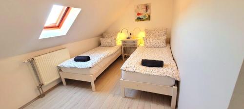 诺茨瓦约Napkert Apartman的小房间设有两张床和窗户