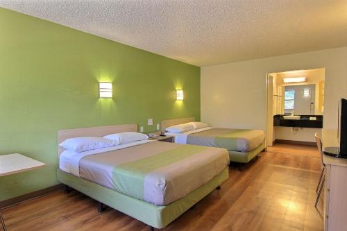 奥斯汀Motel 6 Austin, TX - Central Downtown UT的酒店客房设有两张床和电视。