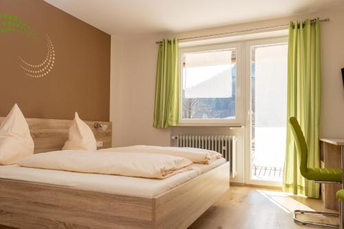 迪特福特沃尔夫斯堡族玛乡村旅馆的一间卧室配有一张带绿色窗帘的床和窗户。