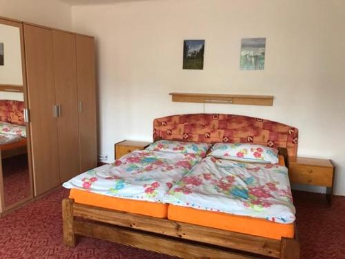 赫鲁巴斯卡拉Apartman Hruba Skala的一间卧室配有一张带木制床头板的床