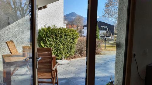 施利尔塞Bungalow mit Terrasse im alpinen Stil的玻璃门通向带桌椅的天井