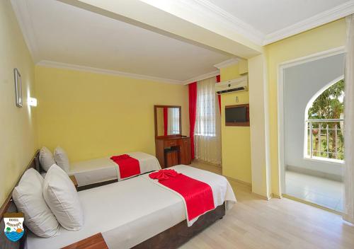 安塔利亚BODENSEE HOTEL的黄色和黄色墙壁的客房内的两张床