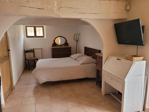 BaudinardGîte Les Fourches的一间卧室配有一张床和一台平面电视