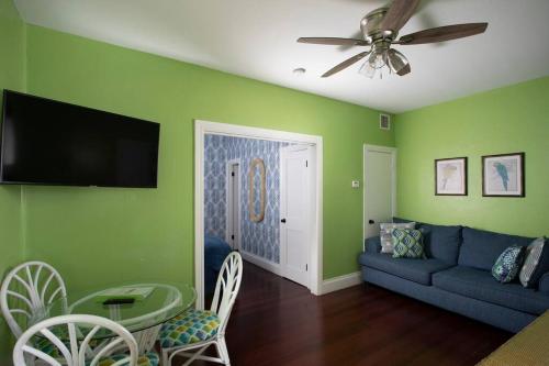 基韦斯特Duval Street Suite with pool的客厅设有绿色的墙壁和蓝色的沙发
