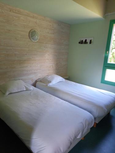 AubazinesHôtel du golf du coiroux的带窗户的客房内设有两张单人床。