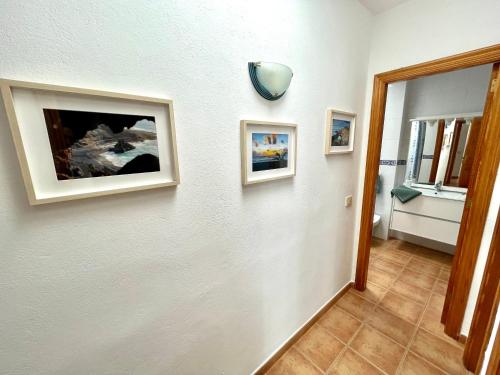 埃尔戈尔福Maresía Apartamento的白色墙壁上带有两张照片的走廊