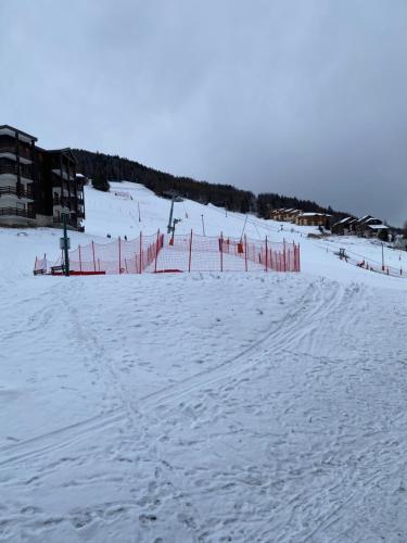 艾姆拉普拉涅Duplex la Plagne Montalbert的雪覆盖的滑雪场,有红色的围栏