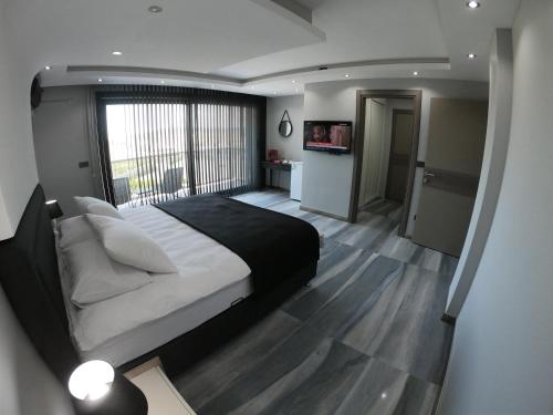伊兹密尔DKD DELÜXE的一间卧室设有一张大床和一个大窗户
