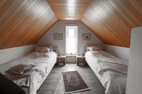 费马恩Lütt Hus Erna的配有木天花板的客房设有两张床。