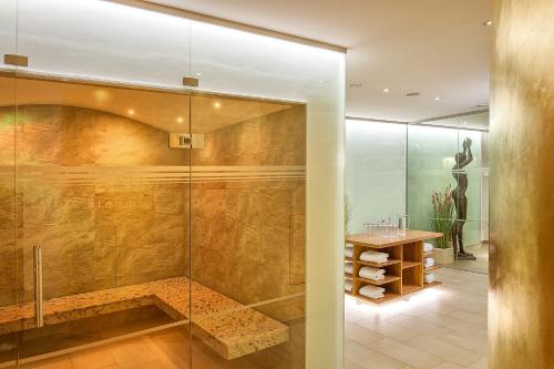 奥斯赛拜-塞林Romantik ROEWERS Privathotel & Spa的带淋浴的浴室和玻璃门