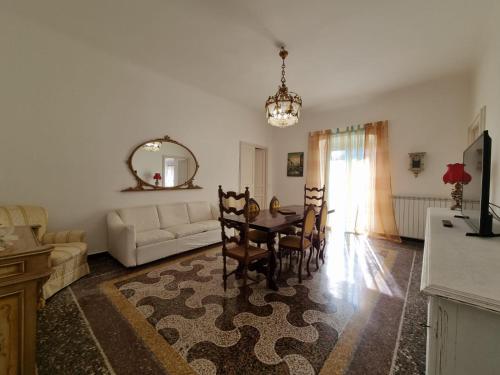 热那亚WOW HOME 2 - 175 mq - posteggio privato - davanti porto traghetti - fino a 10 posti letto - balcone的客厅配有桌子和沙发