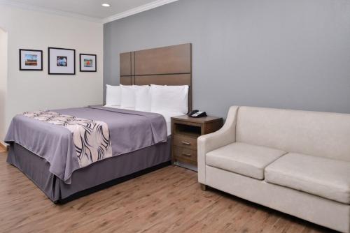 亨博尔Americas Inn & Suites IAH North的酒店客房,配有床和沙发