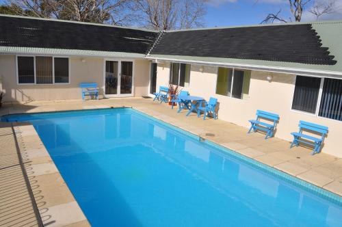 Sandford班布拉礁度假屋的一个带蓝色椅子的游泳池