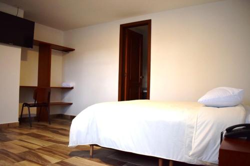 帕斯托Hotel Villa Isabel的卧室配有白色的床,铺有木地板
