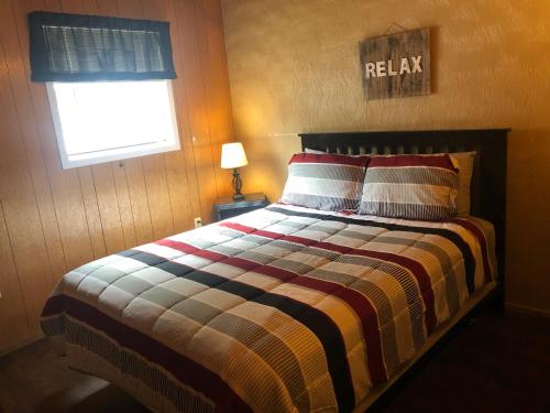 阿尔托High Country Lodge的一间卧室配有带条纹棉被的床和窗户