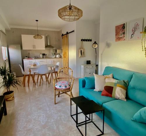丰卡连特德拉帕尔马Casa Ninive的一间带蓝色沙发的客厅和一间厨房