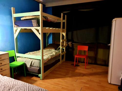 墨尔本St Kilda East backpackers' hostel的一间卧室设有两张双层床和一张红色椅子