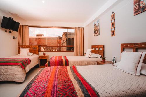 库斯科Dreams House Cusco的酒店客房设有两张床和窗户。