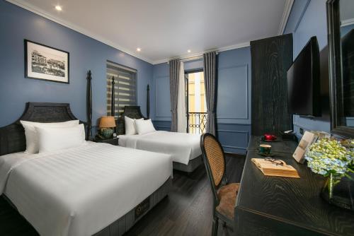 河内Hanoi Paradise Center Hotel & Spa的酒店客房配有两张床和一张书桌