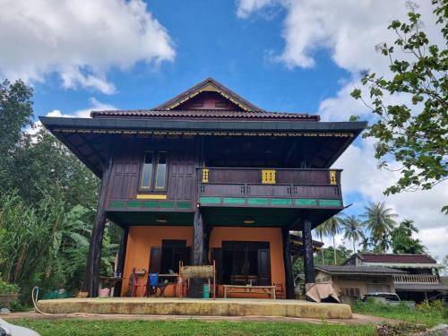 Ban Khu Ha Nai (1)โฮมสเตย์บ้านนายสิงโตเขาคูหา的茅草屋顶的房子