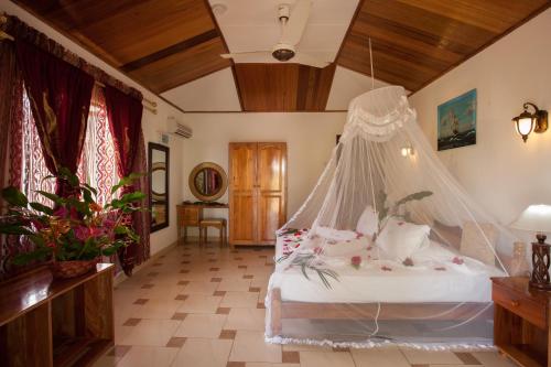 拉迪格岛Etoile Labrine Guest House的一间卧室配有一张带蚊帐的床