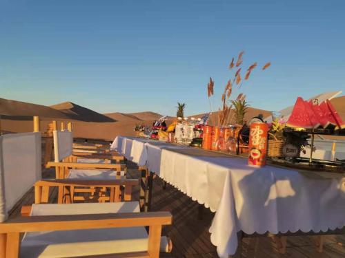 敦煌敦煌鸣沙山野奢国际沙漠度假酒店的沙漠中的一排桌椅