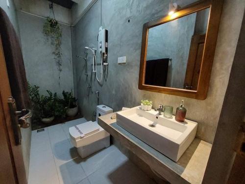 阿努拉德普勒Kingcity Resort的一间带水槽、镜子和卫生间的浴室