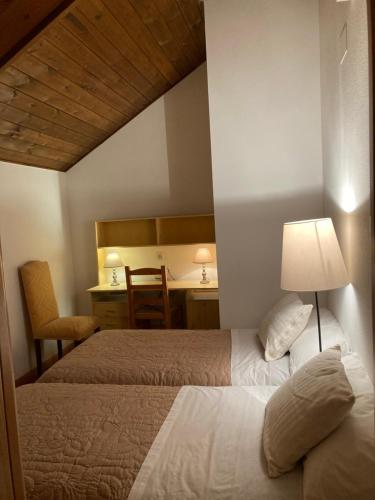 哈卡Ático Jaca a 200 m de la Ciudadela的一间卧室配有两张床、一张桌子和一张桌子
