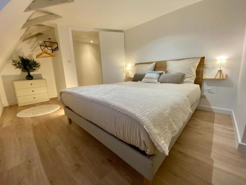 蒙蒂尼亚克Montignac-Lascaux - Les Pierres d'Alexandre的一间卧室配有一张带白色床单的大床
