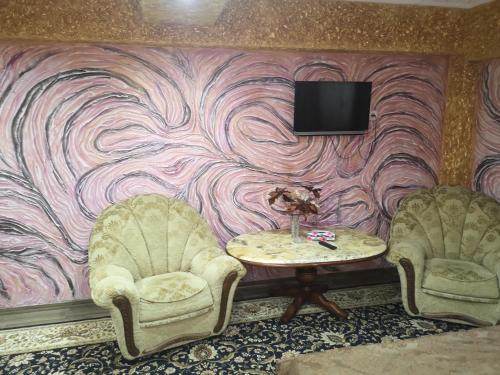 基希讷乌Golden Rose的两把椅子和一张桌子,墙上配有电视