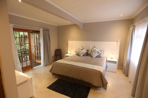圣卢西亚Rhino Coast Guesthouse的一间卧室配有一张大床和两盏灯