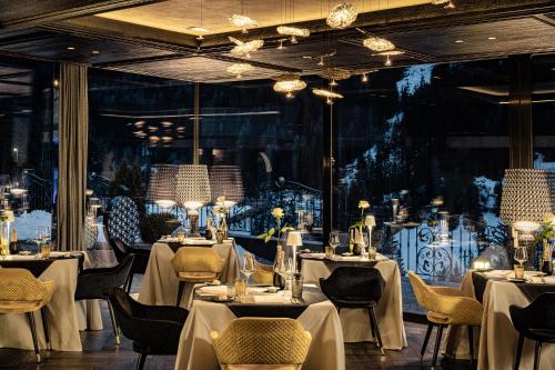 奥蒂塞伊Alpin Garden Luxury Maison & SPA - Adults Only的餐厅设有白色的桌椅和大窗户